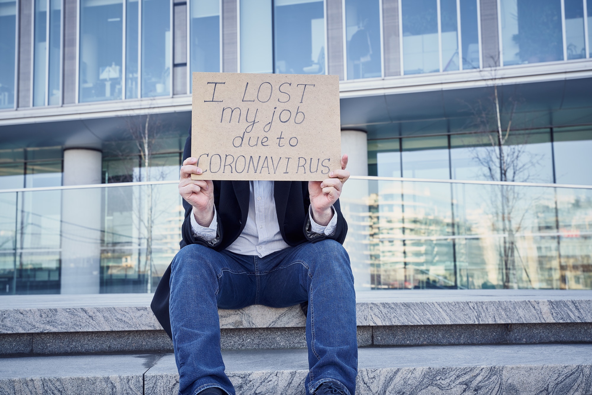 Job loss due to COVID-19 virus pandemic concept. Unrecognizable man holds sign "I lost my job"