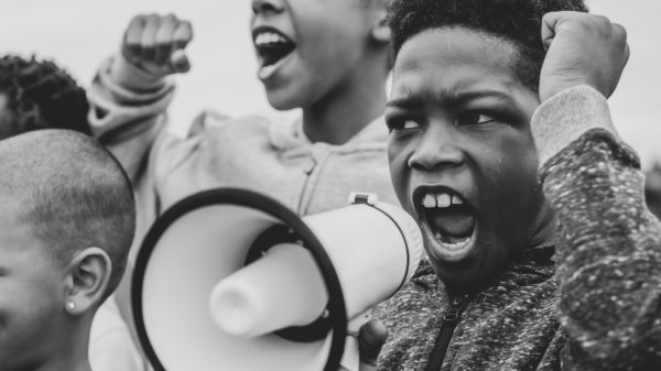 Young boy shouting on a megaphone in a protest