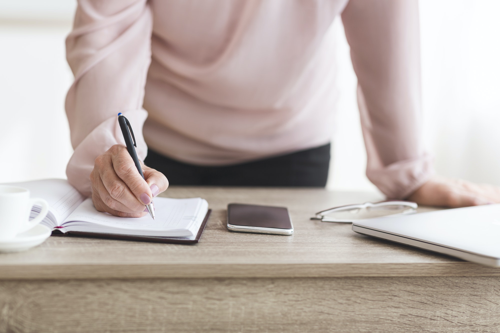 Senior woman writing down tasks for day