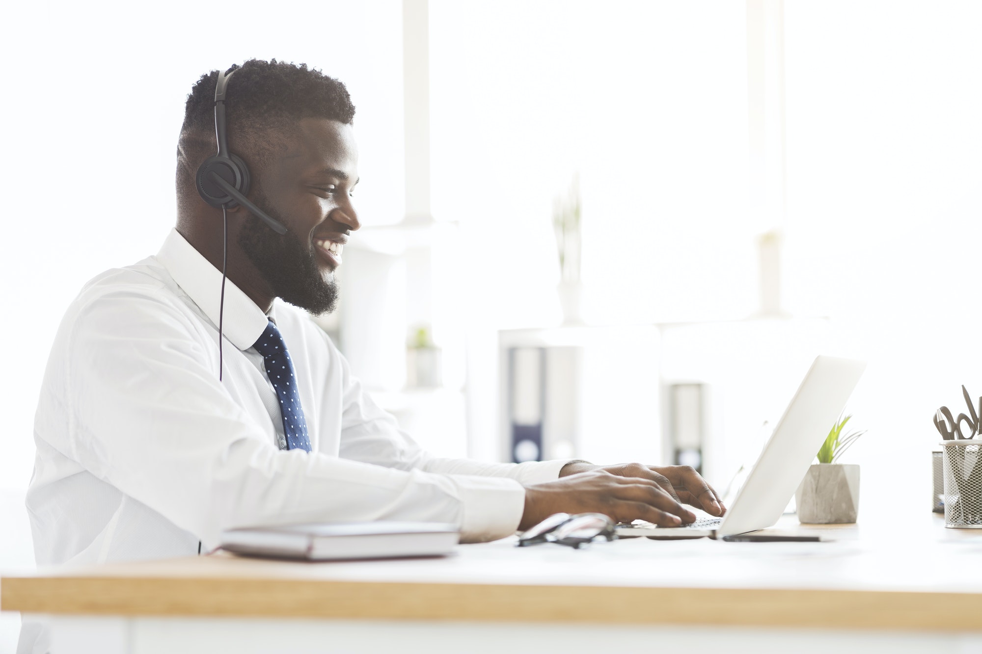 Side view of young customer service agent working in office