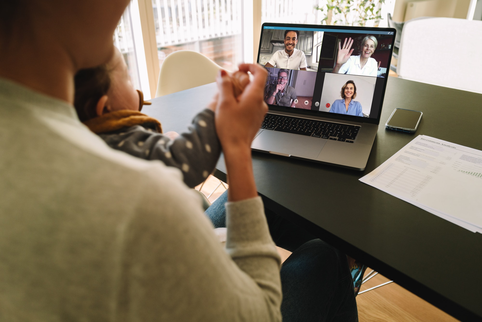 Woman at home video conferencing with colleagues