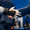 Hand of a businessman shaking hands with a Android robot.